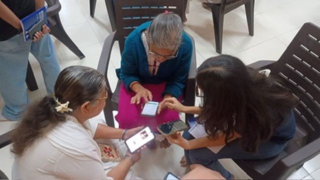 Female volunteer showing a tablet to an elderly woman