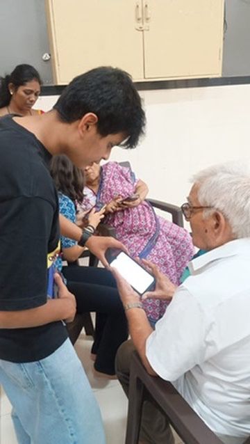 Volunteer presenting to a seated circle of senior citizens