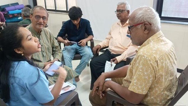 A Tech Mitra volunteer leading a discussion with a group of senior citizens at a workshop